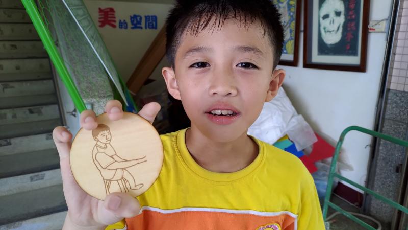 三年級的小弟弟把家人照片繪製成圖像，完成雷雕杯墊。