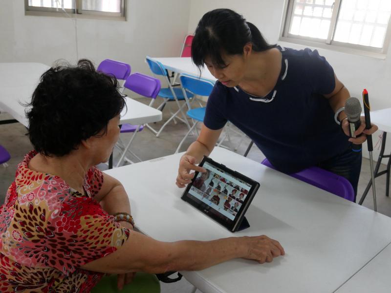 蔡老師指導學員選照片來印作袋子