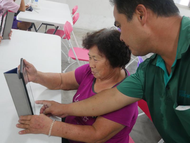 學員阿媽帶兒子來幫忙如何使用平板電腦.等回到家可以在繼續玩.