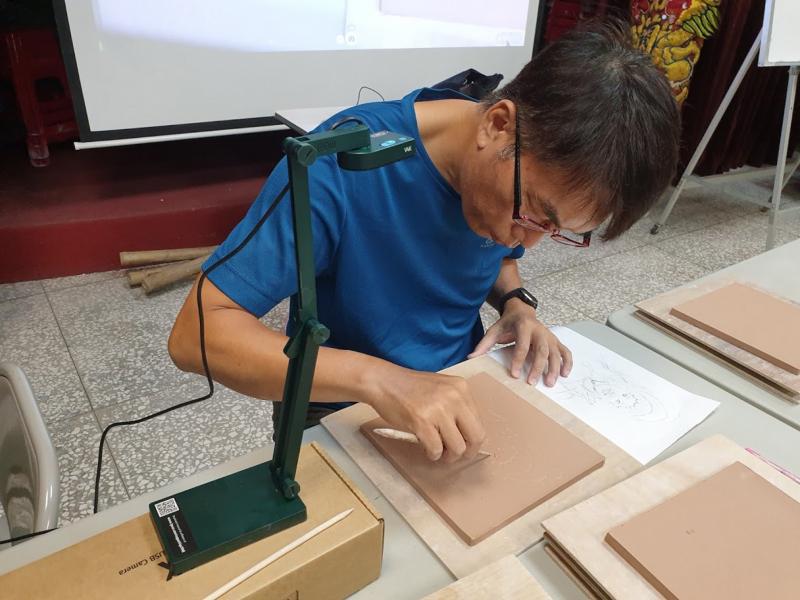 老師用實物投影機操作繪畫手法