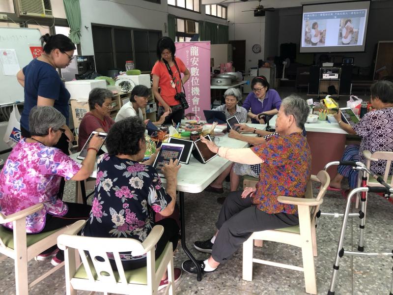 老師從旁協助學員使用平板