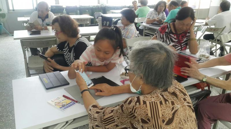 民眾互相協助使用平板