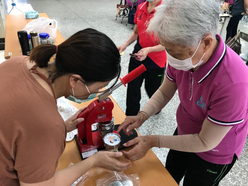 助教很認真的解説胸章機的操作過程，長輩也聼得似懂非懂