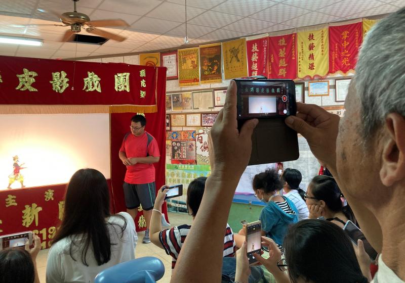 學員認真拍攝皮影戲劇團團長介紹皮影戲的歷史與故事