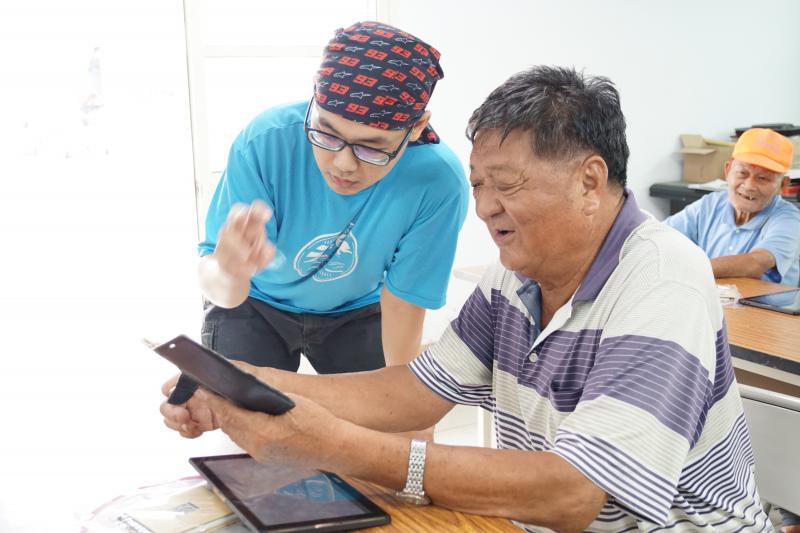 講師教導社區民眾抄操作平板電腦