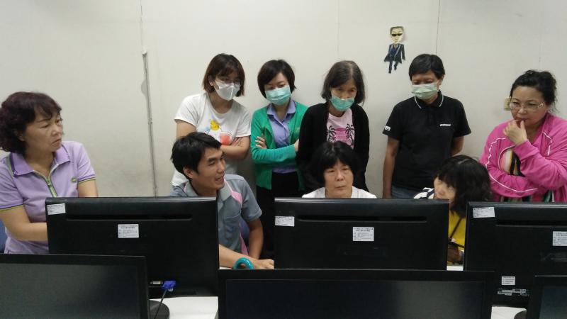 老師講解操作步驟，所有學員圍在一起聽課