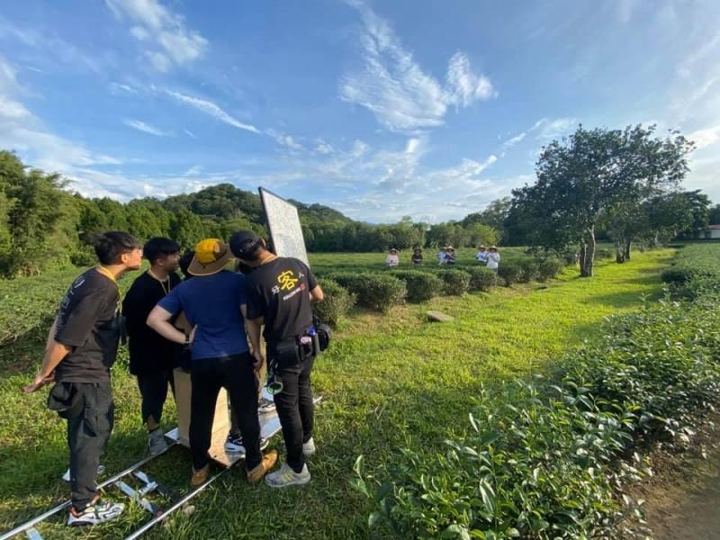 拍攝人員與女主角在茶園享用米苔目