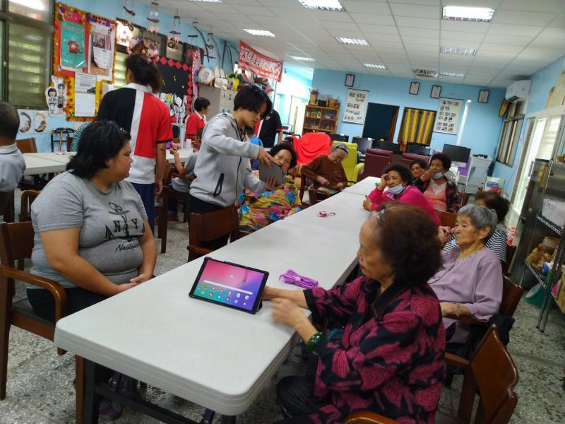 學員與照服員一同討論在平板上的三高資訊。