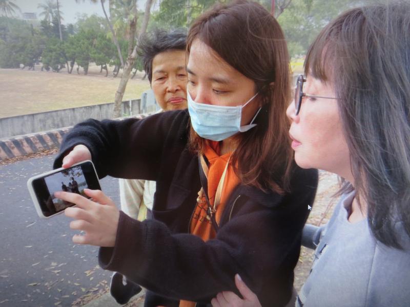 在二仁溪畔講師傳授使用九宮格拍照手法，教導學員如何利用手機中的內建功能布景、拍照。