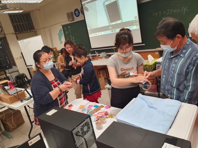 向老師領取膠帶及學員互相協助下載手機line拍貼操作技巧.