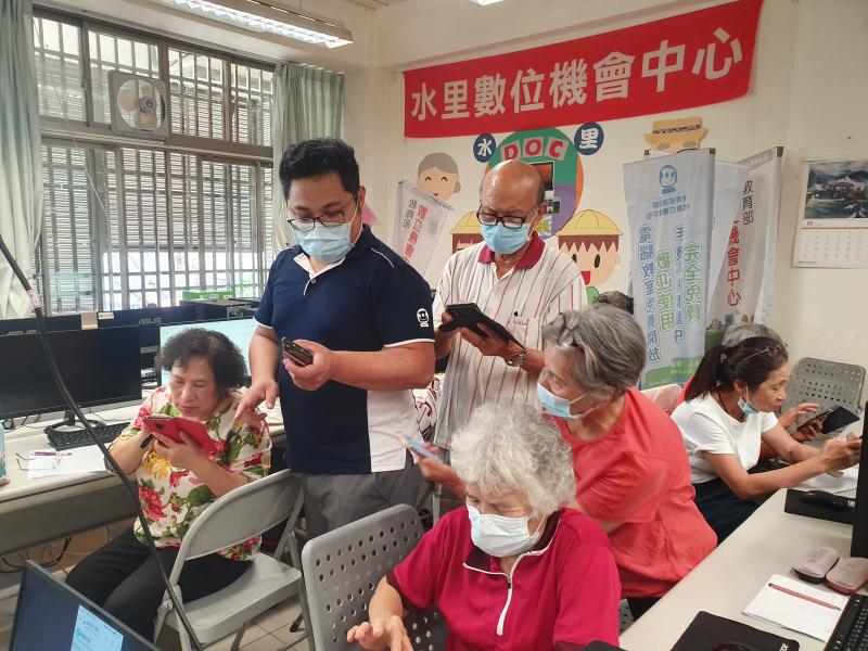 老師在旁指導學員電腦及Google搜尋及下載至手機首頁.