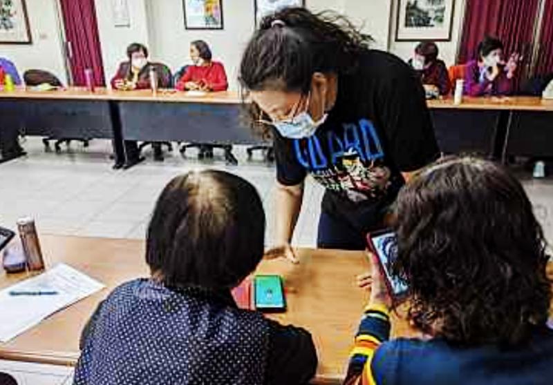 講師認真地指導長輩使用LINE社群軟體