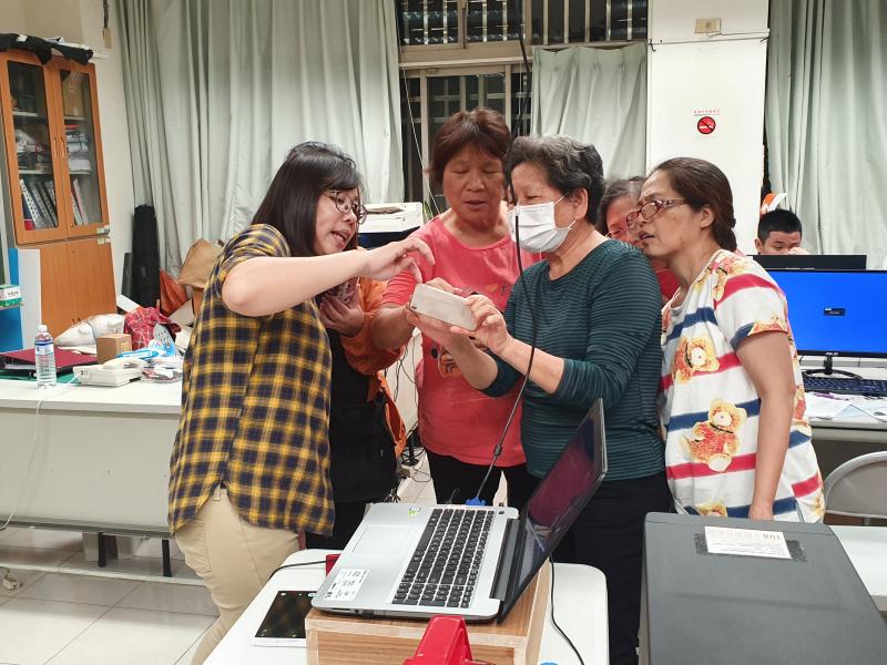 老師幫學員解決手機操作上問題.