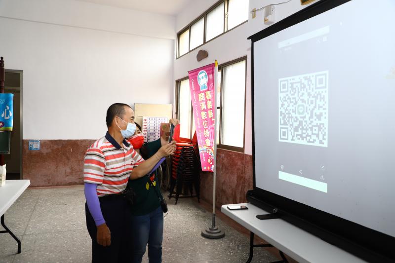 講師個別指導民眾如何掃QR CODE，加入群組