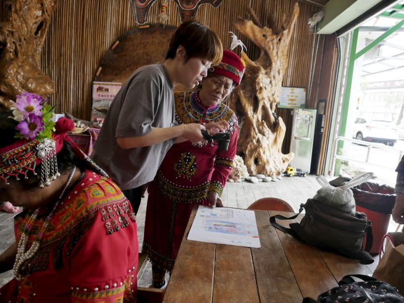 數位學習融入，長輩使用行動裝置將手繪圖稿翻拍保存。