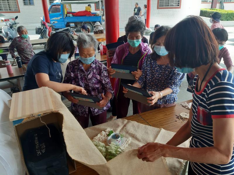 學員拿起平板在輔導員協助下拍下美美的香草茶照