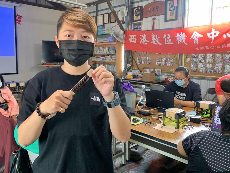 學員拿著自己雷射雕刻圖案的皮鑰匙圈