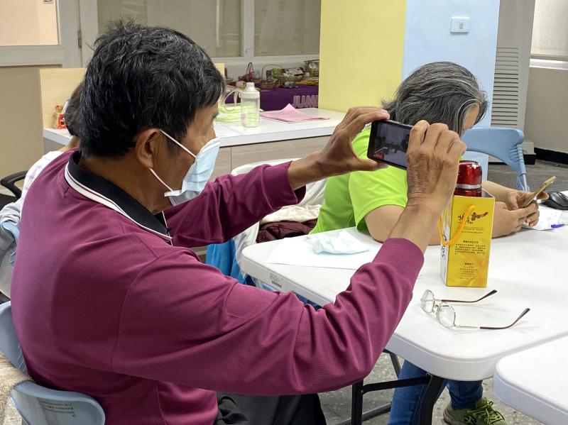 學員使用手機，練習拍設前方人物