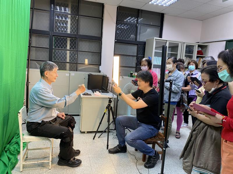 老師指導學員利用手機拍攝個人照片。