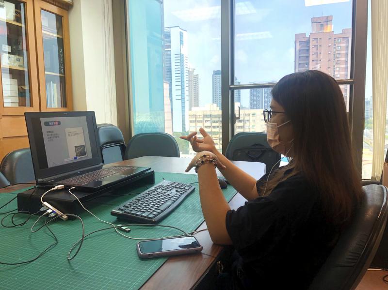 電腦前，講師進行海報設計遠距教學