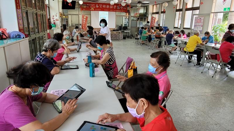 長者認真操作老師教授的APP益智遊戲。