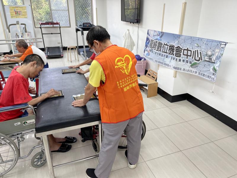 教保員大哥協助學員如何使用平板