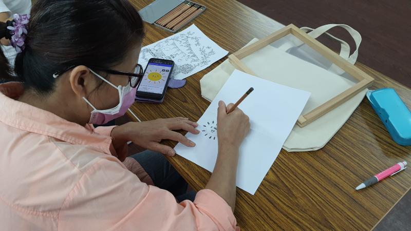 學員用手機找喜歡的圖樣，描摹在白紙上。