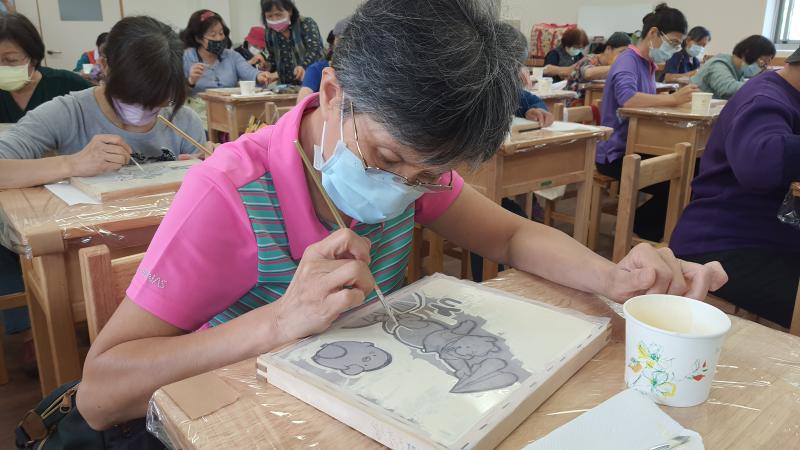 學員聚精會神用油漆遮蓋網眼。