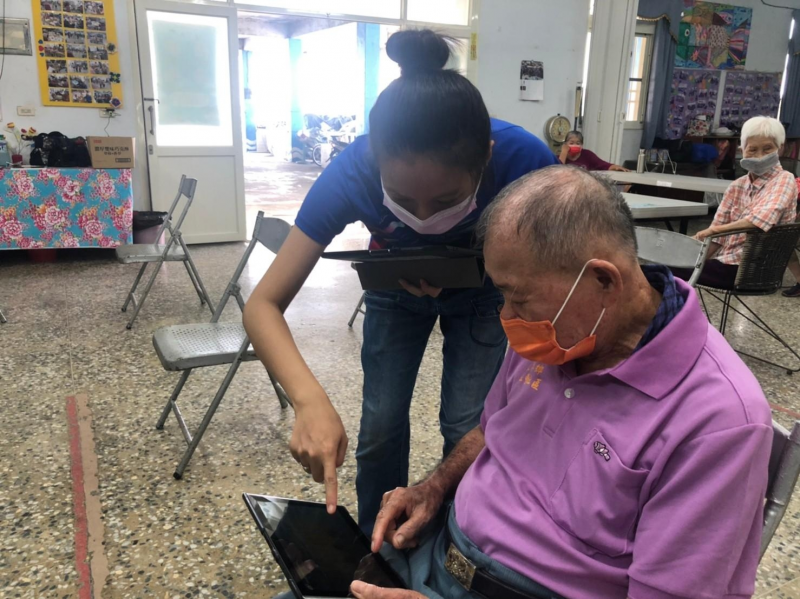 志工協助長者使用資訊設備上網查證假消息。