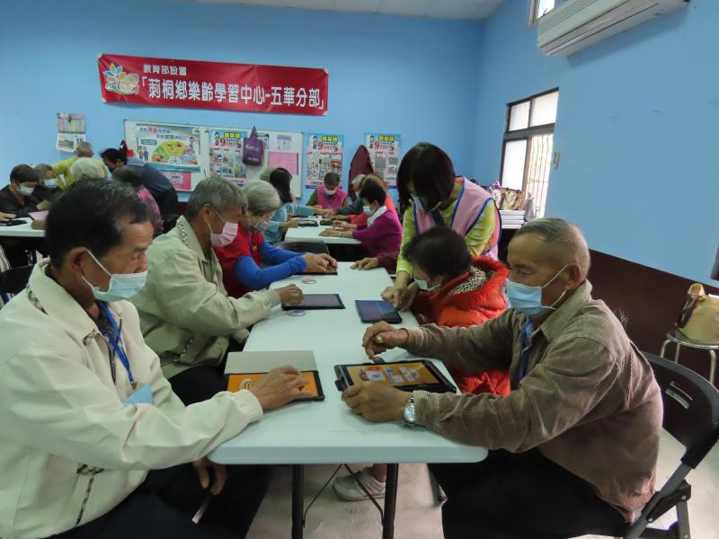 志工協助長輩操作平板.學會如何去滑動手指操作