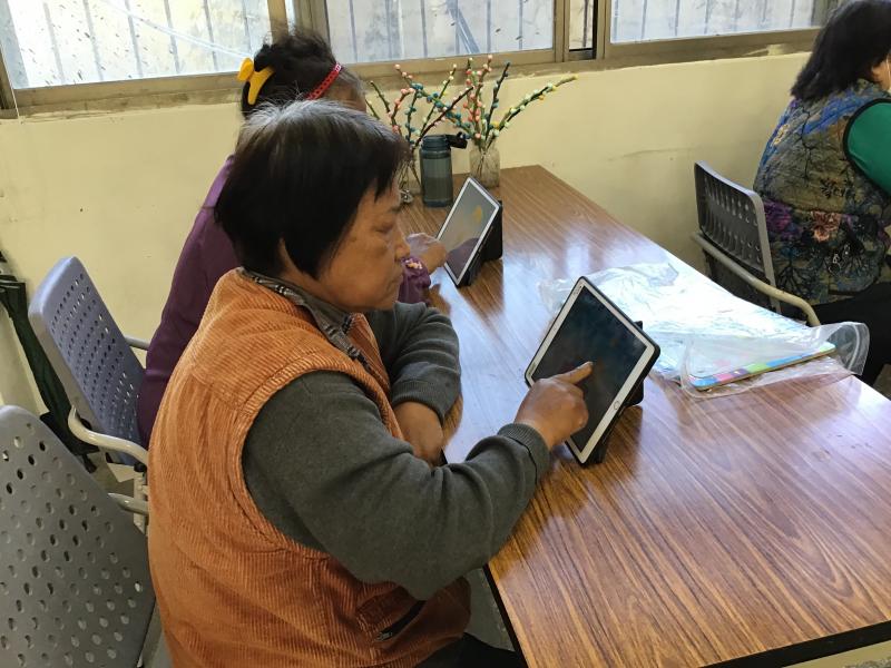 中高齡學員拿著平板操作