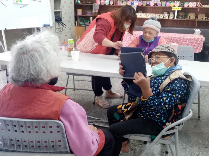 學員拿著平板練習對著她的同伴拍照