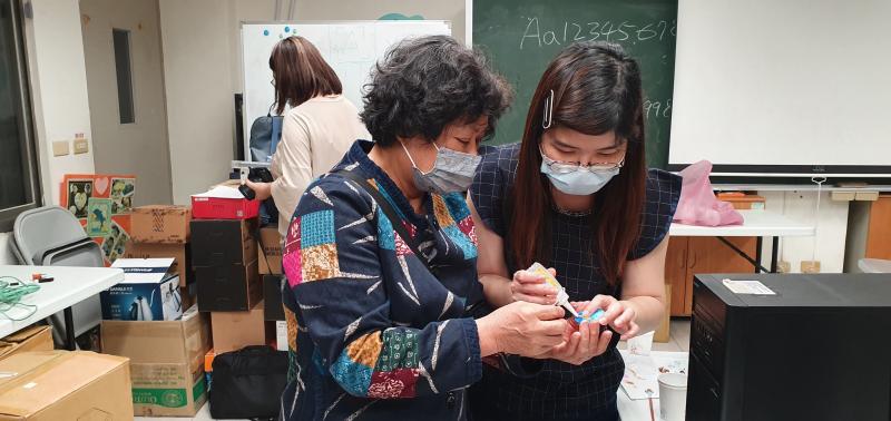 老師指導學員保麗龍膠黏貼物要再按壓一下卡牢靠.