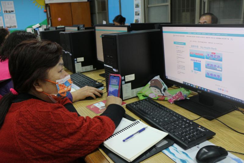 學員仔細看著老師示範健康存摺註冊