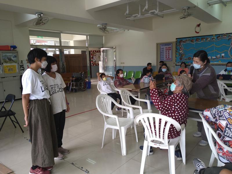 學童站立擺姿勢，由長輩進行數位拍照