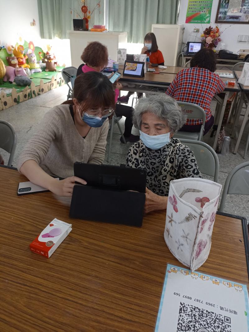 駐點人員教著學員學平板拍攝技巧，一對一教學著，有些不好意思問的問題，馬上詢問駐點人員