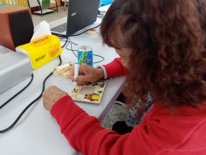 學員在桌上拿彩色筆彩繪木製相框