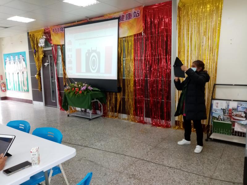 學員站在前面拿平板對著大家拍照