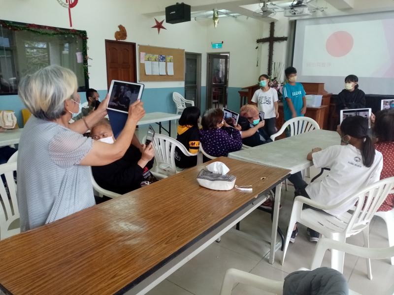 學員拿著平板對著前面的學童表演進行錄影