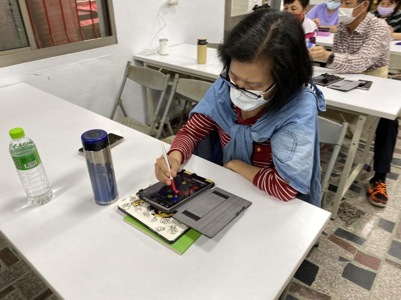 學員利用平板下載遊戲APP動動手動動腦。