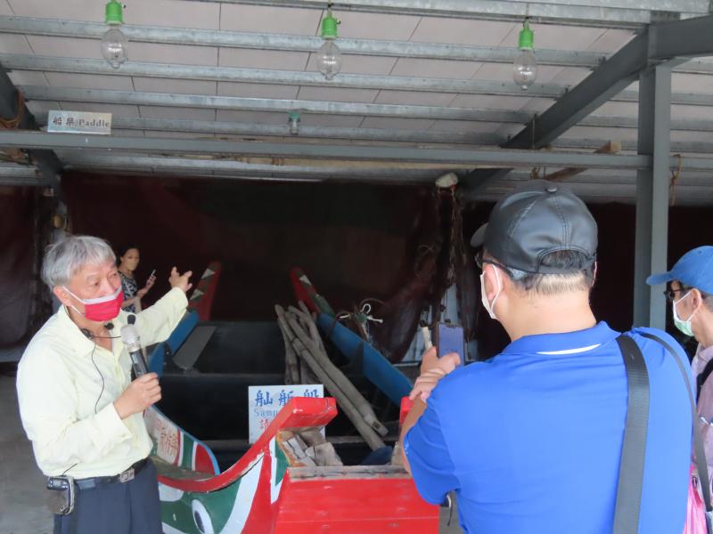 學員認真聽老師介紹「牽罟」文化，並用手機錄音功能將導覽內容記錄下來。