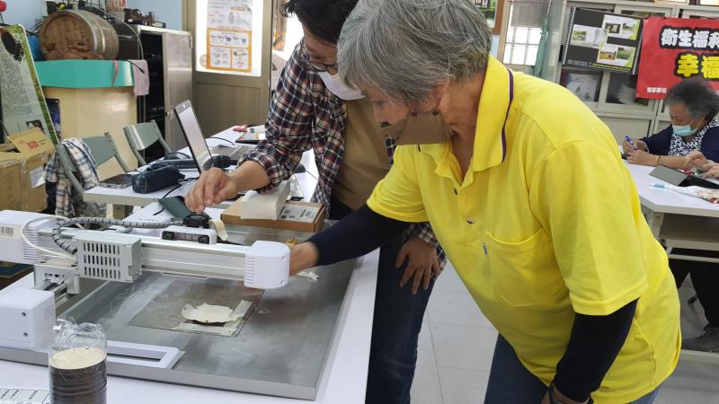 講師帶學員操作雷雕機。