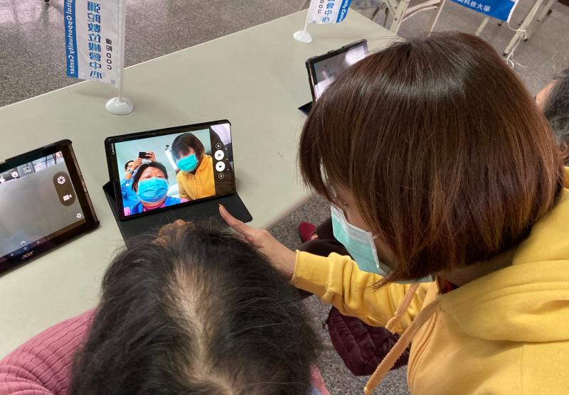 講師親切的與學員一起操作平板