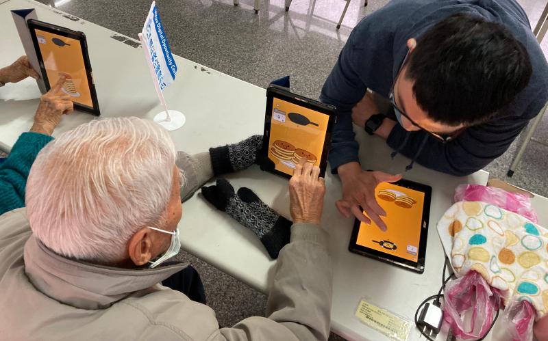 老師與90幾歲的長輩一起操作平板，互相競賽
