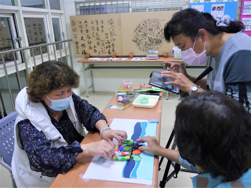 學員們圍繞在平板旁操縱偶