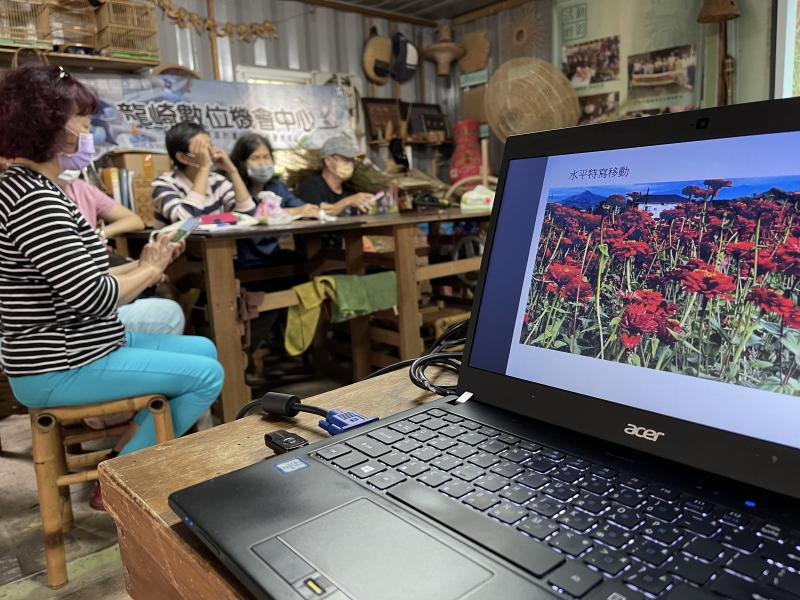 講師使用筆電與投影機在大螢幕上跟學員上課