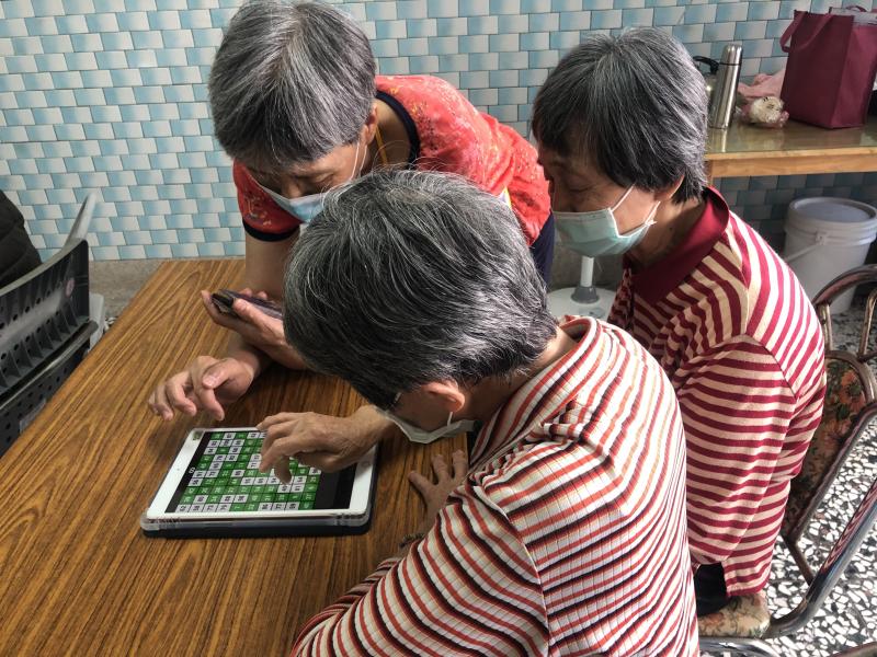 志工協助學員動腦動手玩益智遊戲