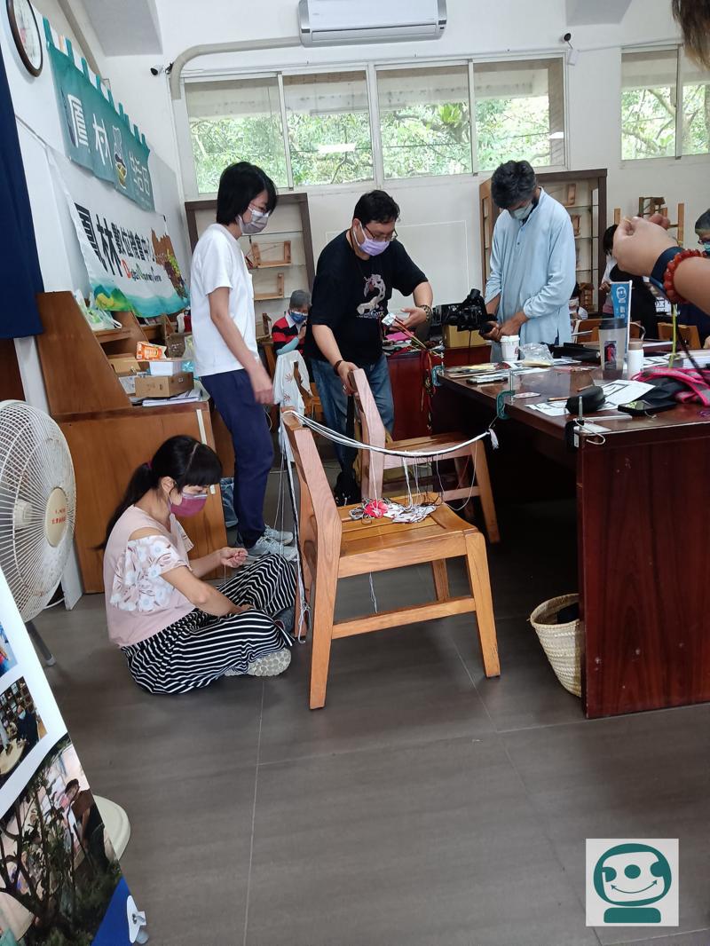 坐在地上認真做織帶的學員