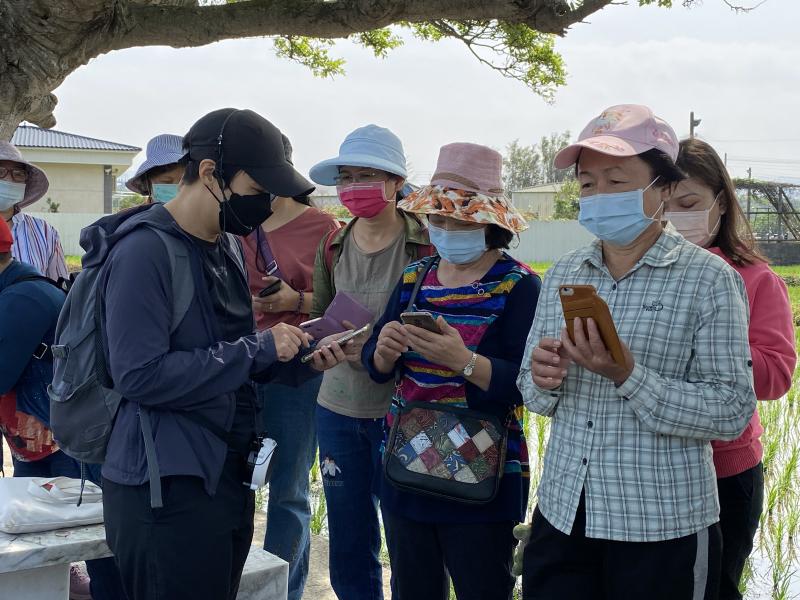 學員在戶外向老師請教手機操作的方式