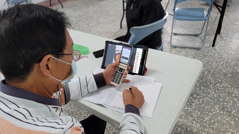 學員練習舊型手機操作功能。